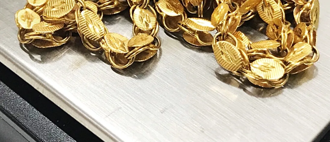 Cadenas de oro sobre la báscula de la joyería